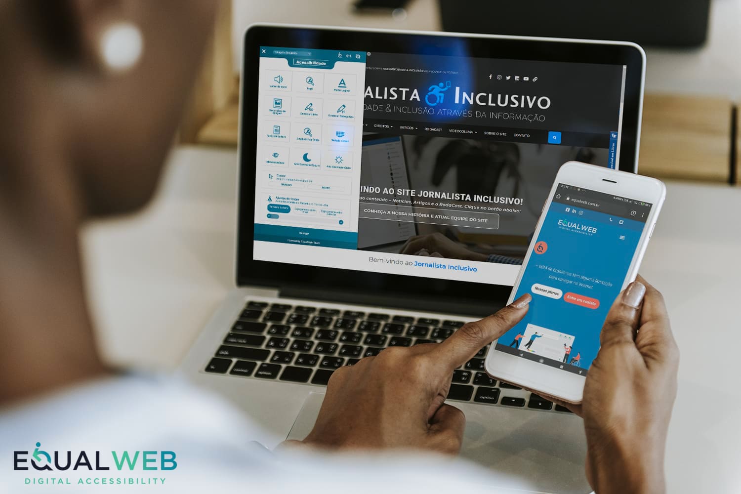 Mãos segurando smartphone com site EqualWeb; laptop ao fundo exibe página do Jornalista Inclusivo com ferramentas de acessibilidade.